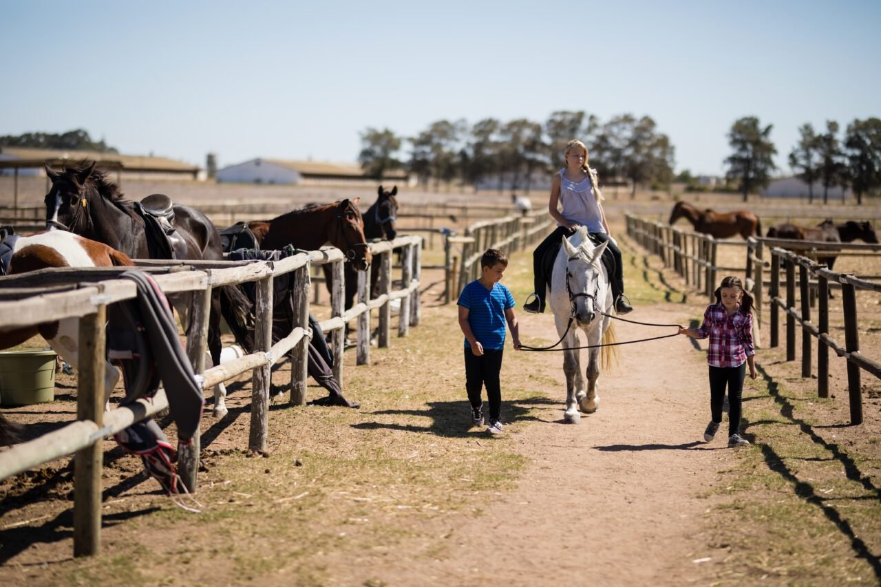 Kids riding a horse in the ranch