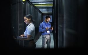 Man, woman or technology in server room, IT engineering or software programming for cybersecurity,