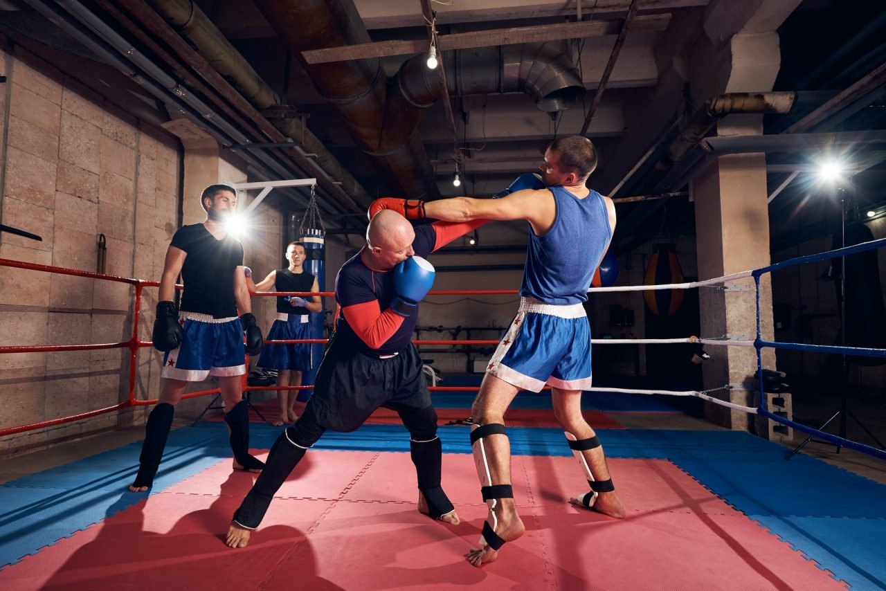 Boxers training kickboxing in the ring at the health club