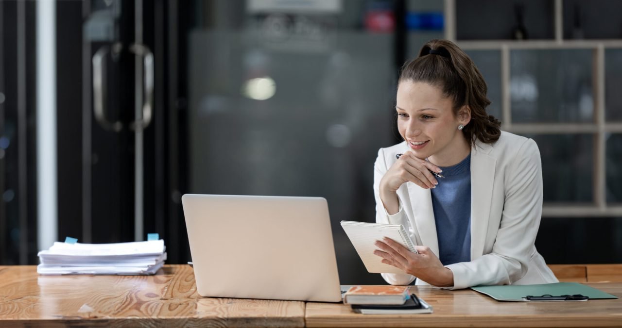 Young Businesswoman Using Computer in Modern Office, Working on Financial and Marketing Projects.