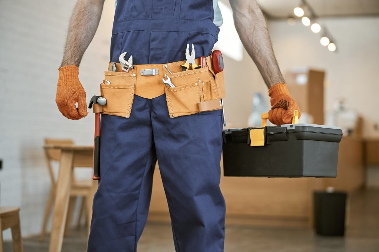 Male electrician in gloves holding tool box set
